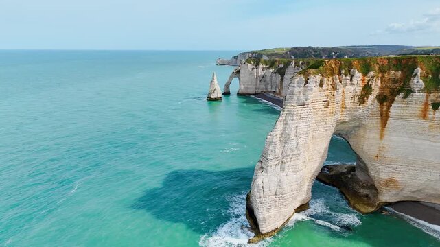 Etretat on Normandy coast, France, famous travel destination with iconic cliffs, natural arch and coastal scenery. Aerial view
