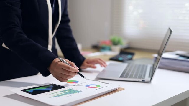 Businesswoman analyzing financial data, market research and using a laptop