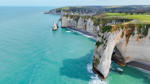Etretat cliffs on English Channel coast in Normandy, France. Aerial view of limestone coastline, sea arch and famous French seaside landmark
