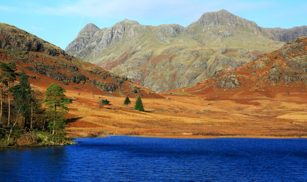 Blea Tarn reflects the Langdale Pikes in the Lake District during a clear day in Cumbria, England