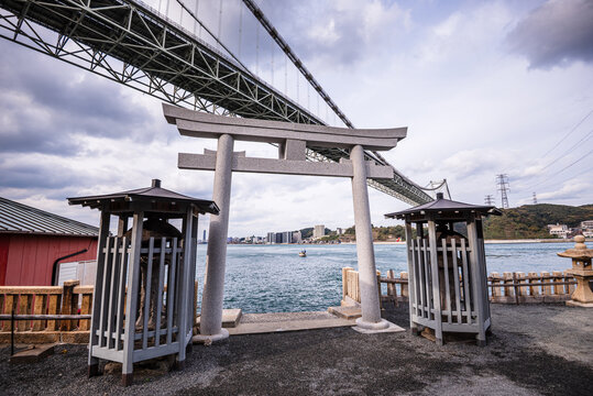 Torii gate and shrine with Kanmon Bridge in view at Mekari Park near the Kanmon Strait in Kitakyushu