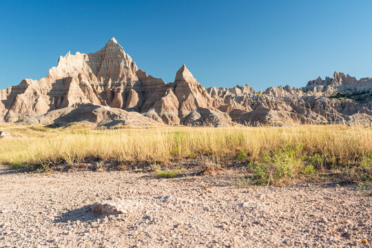 Sharp pinnacles rising above prairie grass in Badlands National Park, South Dakota
