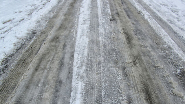In winter, snowy, icy, and muddy roads and landscapes with tire and footprints.