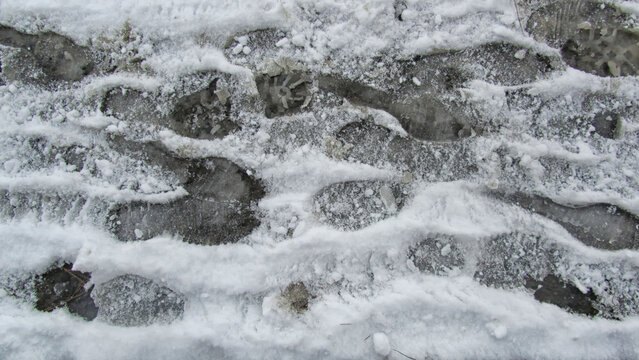 In winter, snowy, icy, and muddy roads and landscapes with tire and footprints.