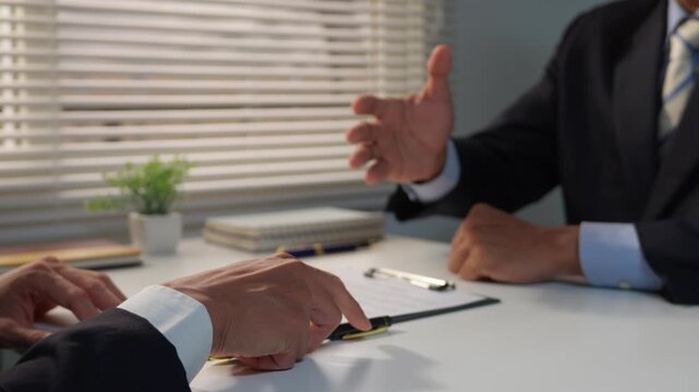 Businessmen signing a contract and shaking hands to finalize a successful deal