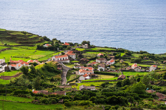 Scenic view of patchwork fields and rural homes above the Atlantic coast in Flores Island, Azores, Portugal at sunset