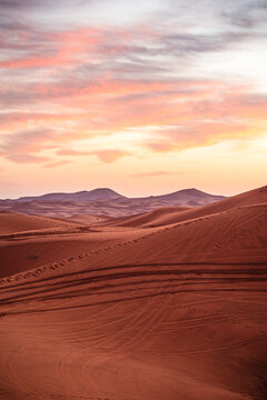 Sunrise colors fill the sky over the Erg Chebbi dunes in the Sahara Desert, Morocco