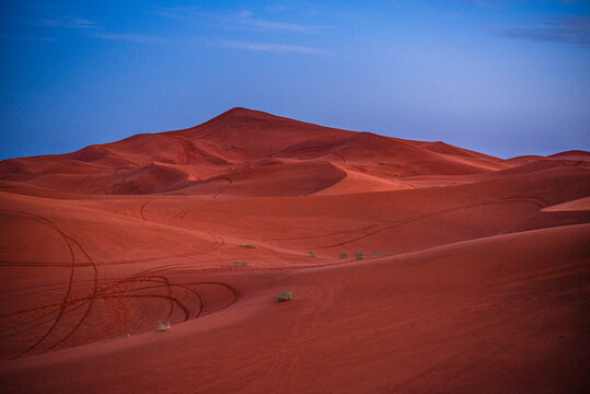 Light falls on sand ridges in desert landscape near Merzouga in Morocco at the end of the day
