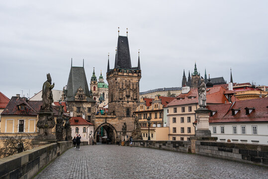 View of Charles Bridge and Lesser Town Bridge Tower with statues in Prague