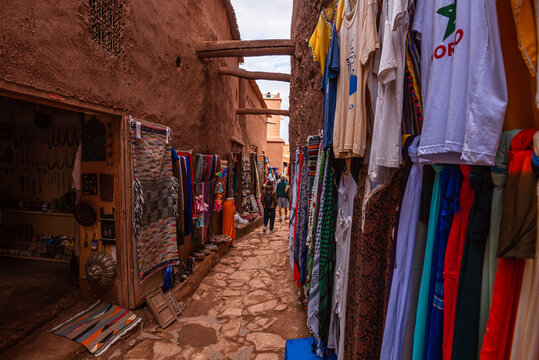 Narrow alley filled with local goods in a market in Ait Ben Haddou on an overcast afternoon