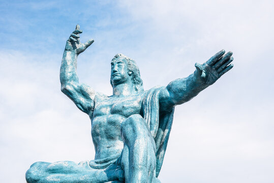 Peace Statue in Nagasaki Peace Park shows figure pointing to sky and extending hands in prayer for peace in Japan