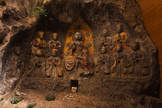 Close-up of colorful carvings within the Usuki Stone Buddha site in Japan showing various forms of Buddha and bodhisattvas