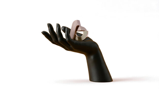 A black hand holds a small silver object on a white background
