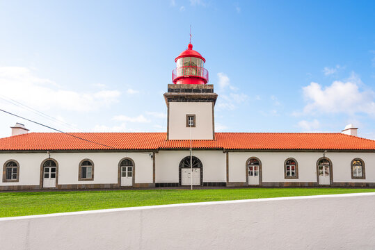 Lighthouse located on Flores Island with red dome and white buildings in a clear sky