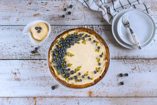 Blueberry dessert with cream on wooden table at kitchen setting