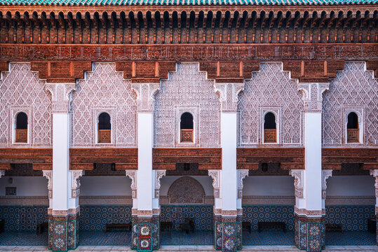 Exploring the upper gallery of Ben Youssef Madrasa with stucco reliefs and zellij tilework in Marrakesh