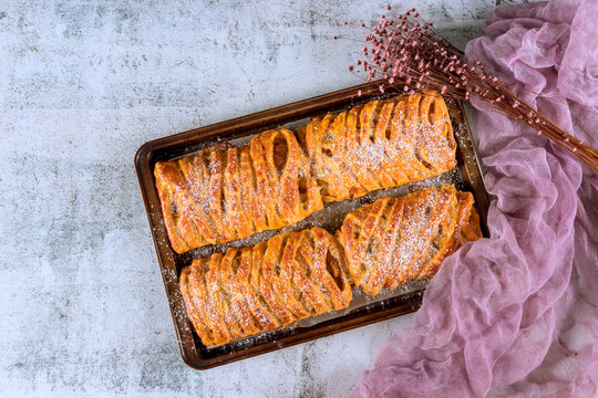 Bakery tray holds fresh pastry treats with powdered sugar on top
