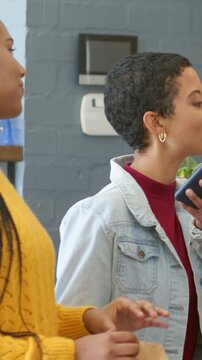 Vertical video: Fixing hair, left in mustard holding bag; right raising phone, showing text at shop