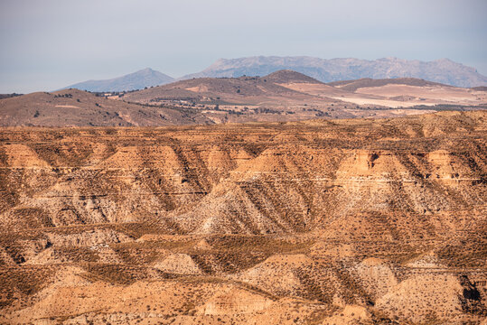 Terraced sediment layers show geological history in a landscape with prehistoric structures in Spain
