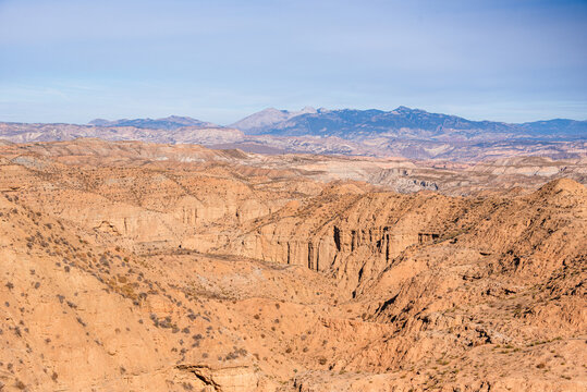 Deep ravines reveal stratified clay and sandstone layers in Spain's Gorafe, showing geological features from the Miocene epoch