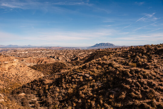 Rolling hills under a wide sky in Gorafe Desert, showcasing geological features and isolation in Andalusia, Spain