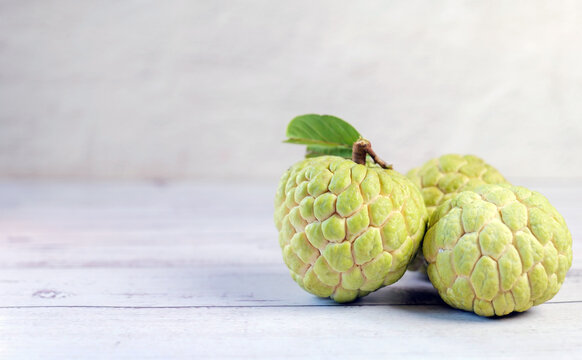 Fresh Sugar Apple (Custard Apple) with Green Leaf on Wooden Table
