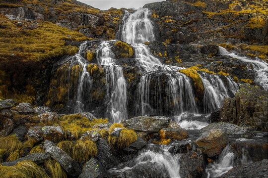Dramatic waterfall flowing over rocks in Coppermines Valley during cloudy weather in the Lake District National Park
