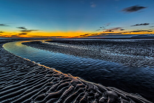 Sunset along the sandy shore of Walney Island with views of distant Black Combe and the Irish Sea on August 29 2022