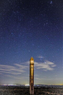 Cumbrian Coast sky with stars and the Needle tower lights at night near Barrow-in-Furness