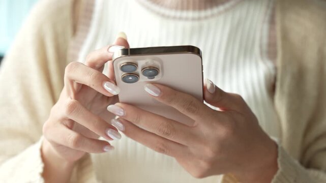 Close-up of a person using a smartphone for messaging, social media, or mobile business in a modern indoor setting.