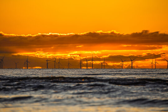 Sunset view over Walney Wind Farms from Sandy Gap in Westmorland and Furness during evening hours in the United Kingdom