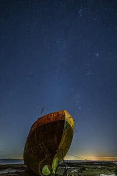 Starry skies above the derelict trawler Vita Nova on the coast of Cumbria with clear night visibility