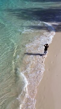 Aerial View of Man Walking on Tropical Beach Shore