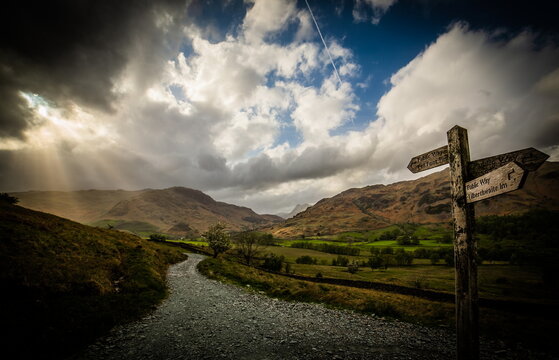 Clouds gather over Little Langdale Valley with a signpost directing hikers in the Lake District