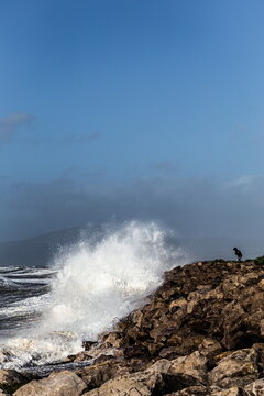 Breezy day at the coast with waves crashing on rocks near Black Combe in the UK