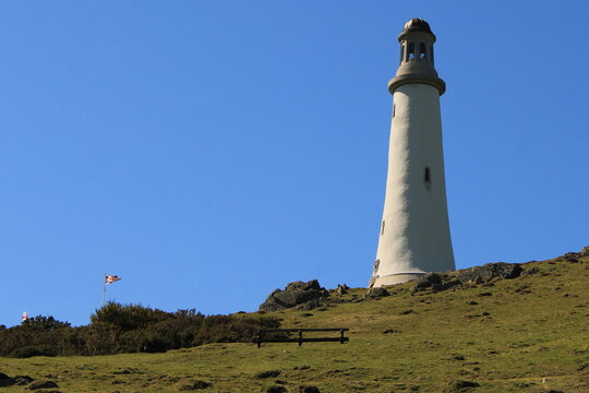 View from Birkrigg Hill towards John Barrow Monument with clear sky above Furness Peninsula in Ulverston, Cumbria