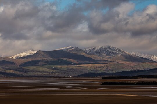 Snow covers the distant mountains of the Lake District from Roanhead near Barrow In Furness