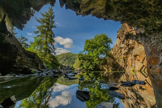 Enjoying views from Rydal Cave in the Lake District while hiking through beautiful nature in Cumbria, UK on a clear day