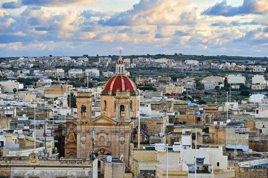 View of Saint Georges Basilica and Victoria from the Cittadella on Gozo Island in Malta during sunset over the Mediterranean Sea