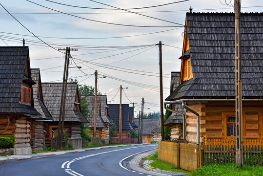 Wooden houses line the road in the village of Chocholow in Malopolska Province, Poland during a quiet afternoon