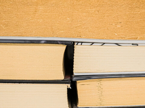 Yellowed vintage book pages and black hardcovers close up