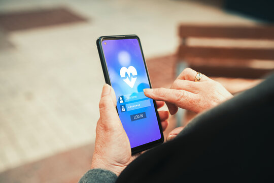 Senior woman logging into health monitoring app on smartphone. Health apps, medical technology, and elderly healthcare management concepts.