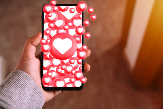 Social media likes and heart notifications flooding smartphone screen. Social media dependency, self-esteem, and digital wellbeing concepts.