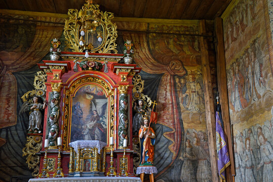 Inside St. Michael Archangels Church in Binarowa with ornate altar and wall paintings