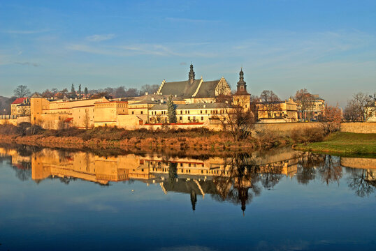 View of Vistula River bank with reflections of buildings in Krakow, Poland during a clear day
