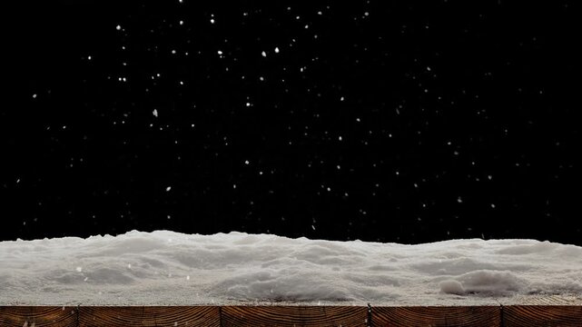 Snow falls on a wooden floor with a pile of snow
