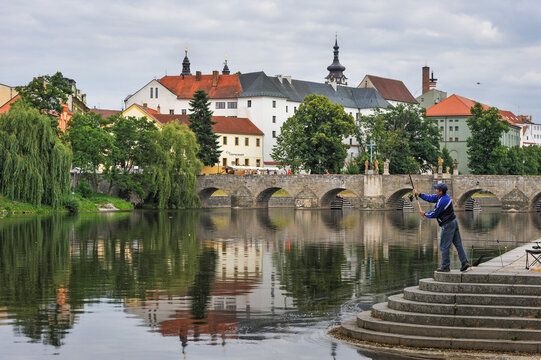 Angler fishing near the old stone bridge over the Otava river in the South Bohemian Region of the Czech Republic