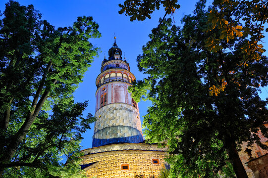 Cesky Krumlov Castle tower stands tall at dusk surrounded by trees in South Bohemia, Czech Republic