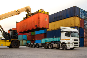 Truck while loading in logistic shipping yard with cargo container. Forklift truck handling truck. Logistic import export concept. Loading and unloading of containers in the port © William