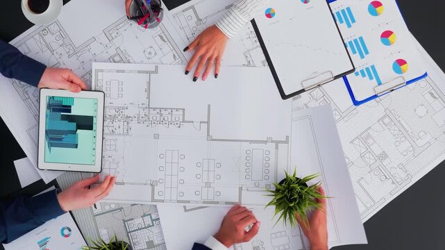 Architects and engineers create a construction blueprint for a modern building, reviewing errors and suggestions during a collaborative boardroom task.
